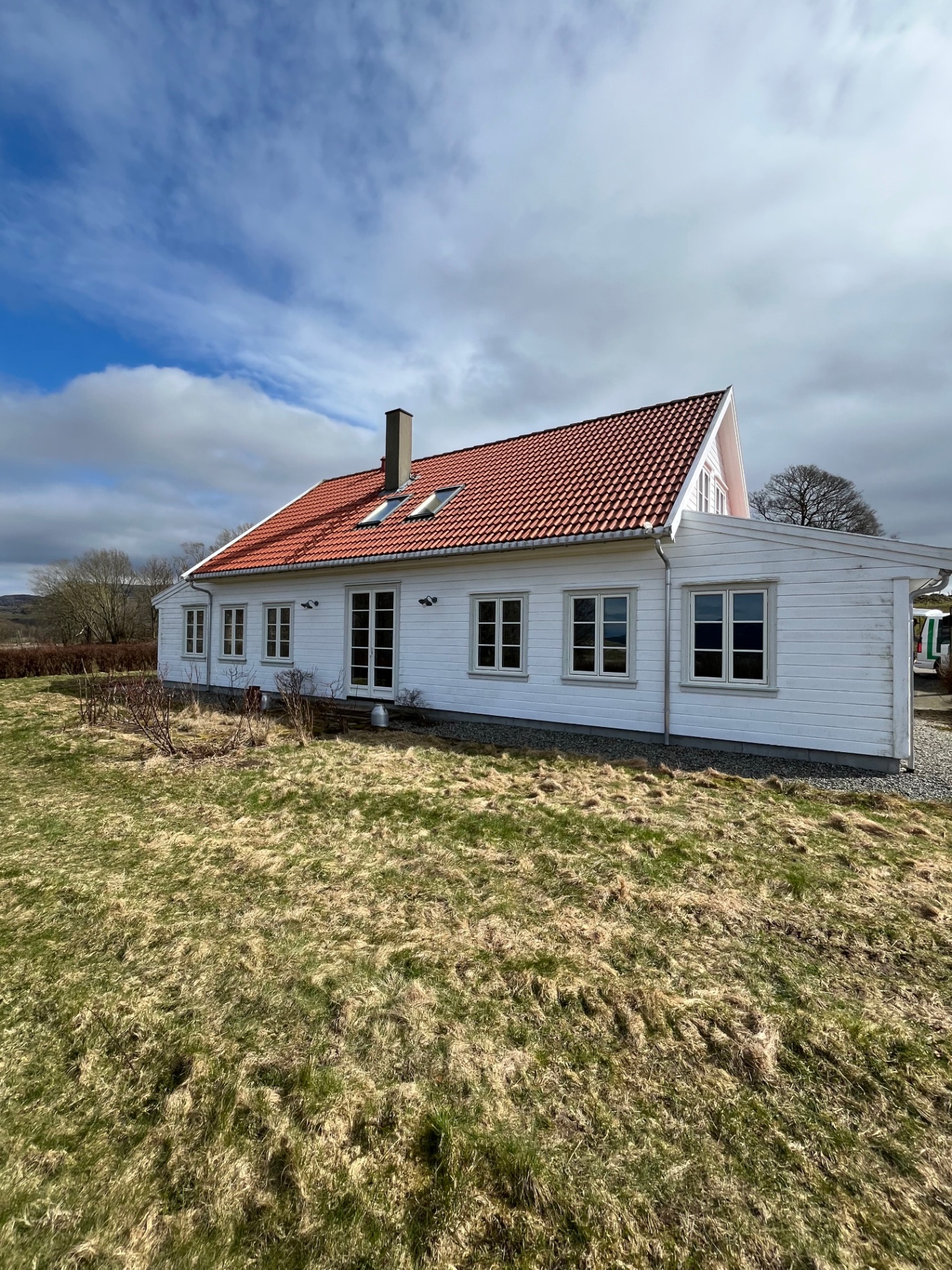 Rehabilitert hvit trehus-bolig med rødt teglstein-tak på Jæren, ferdigstilt av Danielsen Bygg AS