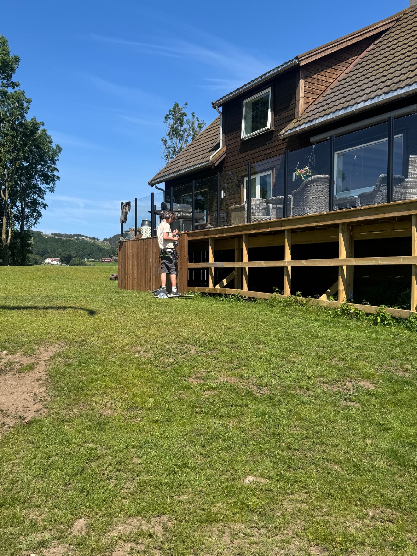 Tømrer fra Danielsen Bygg AS bygger ny terrasse med trykkimpregnert konstruksjon på enebolig